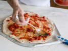 Team Building Cooking Class - Focaccia Pizza Competition in Philadelphia: Chef spreading tomato sauce on focaccia pizza
