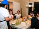 Cooking Class - Coastal Italian Cooking From Scratch: Chef talks to seated guests around a dining table during a Coastal Italian cooking class, with plates of food and wine on the table