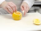 Cooking Class - Spanish Paella From Scratch: Close up of hands squeezing fresh lemon juice onto a wooden cutting board