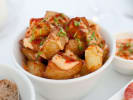 Team Building Cooking Class - Spanish Tapas With an Asian Twist: Crispy patatas bravas topped with gochujang aioli, smoked paprika and chives in a white bowl