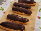 Team Building Cooking Class - French Pastry Bake-Off for Teams: Five freshly made éclairs topped with glossy chocolate glaze and arranged on parchment paper