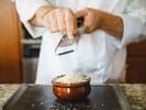 Cooking Class - Essentials of French Cuisine: Grating cheese over French Onion soup