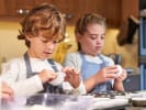 Cooking Class - Kids' Summer Series in the Kitchen in Downtown Dallas: a young boy and a girl preparing cupcakes