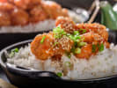 Cooking Class - Chinese-Style Takeout Classics in Denver: Orange chicken topped with scallions and sesame seeds served over steamed rice in a skillet
