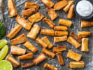 Cooking Class - Lomo Saltado & Peruvian Classics: Overhead shot of crispy golden yuca fries arranged on a tray with lime wedges