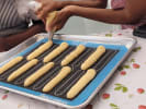 Cooking Class - Chocolate-Dipped French Éclairs in Culver City: Participant piping éclair dough onto a baking mat during a hands on pastry class