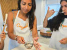 Cooking Class - Italian Fare Reimagined: Participants in aprons preparing and tasting a dessert in a kitchen