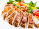 Cooking Class - Flavors of Paris – Date Night in South Bay & Peninsula: Sliced roasted chicken breast with salad – Juicy, herb-seasoned chicken breast sliced and served with a fresh tomato and greens salad on a white plate.