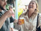 Food Tour - Craft Breweries of New Orleans in New Orleans: Two friends laughing and sipping craft beer samples at a New Orleans brewery tasting room