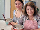Cooking Class - Cute Character French Macarons in Culver City: Two participants wearing aprons and preparing macaron batter during a hands on baking class