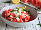 Cooking Class - Farm to Fork in Northern Virginia: Watermelon salad with feta and mint â€“ A bowl of cubed watermelon tossed with crumbled feta and fresh mint, served with a lemon wedge on a rustic white table.
