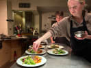 Cooking Class - French Kitchen Romance in Toronto: a young couple plating coq au vin dish with salad