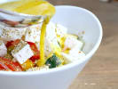 Cooking Class - Signature Mediterranean Menu in Brooklyn: adding vinaigrette to a horiatiki salad