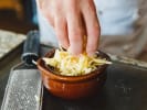 Cooking Class - Festive Parisian Dinner in South Bay & Peninsula: adding grated cheese on top of onion soup