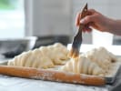 Cooking Class - Bold Croissant Creations in Northern Suburbs: brushing croissant-shaped dough with butter