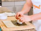 Cooking Class - Japanese Sushi and Asian Noodles in Downtown Dallas: chef adding sushi rice to nori
