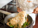 Team Building Cooking Class - Collaborative Chinese Fare in Downtown Chicago: chef making noodles in a wok