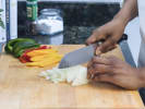 Team Building Cooking Class - Family-Style Grilling in Manhattan: chef slicing onions and bell peppers