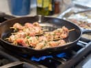 Cooking Class - Sun-Kissed Flavors of the Mediterranean: cooking chicken skewers with herbs in a pan