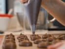 Cooking Class - Bake French Macarons at a Craft Distillery in Boston Proper: piping chocolate macaron batter to form macaron shells