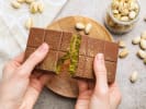 Cooking Class - Craft Viral Dubai Chocolate Bars in Downtown Chicago: hands snapping chocolate bar to show pistachio filling