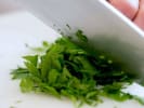Cooking Class - Cajun Fettuccine Pasta in Columbus, OH: Fresh parsley being added to a white bowl for a flavorful pasta dish.