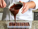 Team Building Cooking Class - DIY Chocolates With Your Crew - NYC in Manhattan: pouring melted chocolate into candy tray