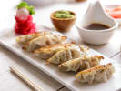 Team Building Cooking Class - The Great Dumpling Competition: plated potsticker dumplings with soy sauce on an elegant plate