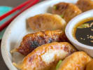 Cooking Class - Fold, Fill and Cook Dumplings in Boston Proper: potsticker dumplings garnished with sesame seeds and scallions