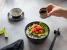 Cooking Class - Make Fresh Poke Bowls in Charlotte: adding sauce to freshly prepared poke bowl
