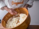 Cooking Class - Make Fresh Poke Bowls in Charlotte: chef in Cozymeal cooking apron preparing sushi rice
