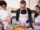 Cooking Class - Fun Sushi Making at a Local Brewery in Atlanta: sushi making class with a group of participants wearing OCzymeal aprons