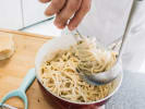 Cooking Class - Master Fresh Pasta & Alfredo Sauce in Toronto: swirling fettuccine pasta in creamy Parmesan cheese sauce