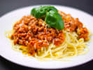 Cooking Class - Master Fresh Pasta & Bolognese in Washington, D.C.: spaghetti bolognese pasta dish on a white plate with basil garnish on top