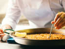 Cooking Class - Spanish Tapas and Traditional Paella in Northern Virginia: chef carefully cooking paella in large pan