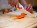 Cooking Class - Heartwarming Vegetarian Indian Feast: cutting carrots on a wooden board