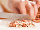 Cooking Class - Spanish Tapas and Traditional Paella in Northern Virginia: chef chopping almonds on wooden cutting board