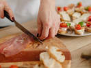 Cooking Class - Rustic Meets Refined Italian Flavors in Northern Virginia: chef slicing fresh prosciutto on wooden cutting board