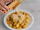 Cooking Class - Gnocchi From Scratch in Louisville: grating Parmesan cheese over gnocchi pasta