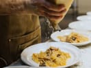Team Building Cooking Class - Hearty Homemade Italian Pasta and More in Toronto: grating parmesan over pasta