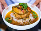 Cooking Class - Southeast Asia Delights - Date Night in Northern Virginia: Grilled chicken breast over chili broth and noodles â€“ A bowl of grilled chicken served atop rice noodles in a rich chili-infused broth, garnished with fresh herbs.