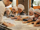 Cooking Class - Foodies Baking: Kids’ Edition in South Bay & Peninsula: kids kneading pizza dough as Chef showcases them how to do it