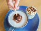 Online Cooking Class - Homemade Hot Cocoa Bombs: hot chocolate bomb being dipped in milk