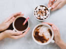 Team Building Cooking Class - Holiday Cookie Decorating Duel in San Francisco: people warming their hands on hot cocoa cups during the holidays