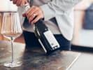 Virtual Wine Tasting - Wine Tasting Fundamentals: person opening a bottle of wine
