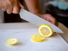 Online Mixology Class - Bubbly Cocktails to Toast the New Year: person slicing a lemon for cocktails
