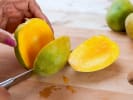 Cooking Class - Classic Fried Rice and Sushi Techniques in San Antonio: person slicing a mango