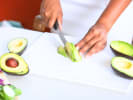 Cooking Class - Sushi With a Twist: person slicing avocado on a white cutting board