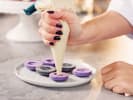Cooking Class - Silver Platter Macarons in South Bay & Peninsula: chef piping filling onto purple macarons in kitchen