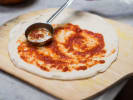 Cooking Class - Homemade Pizza With A Twist in Manhattan: pizza dough with red sauce on it